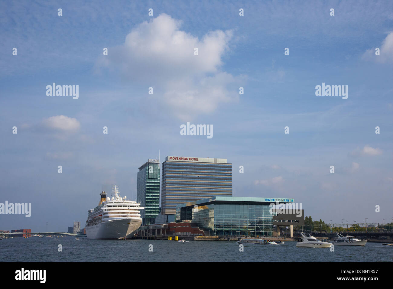 La nave di crociera sul fiume Het IJ vicino a edifici alti, Amsterdam, Paesi Bassi, Europa Foto Stock