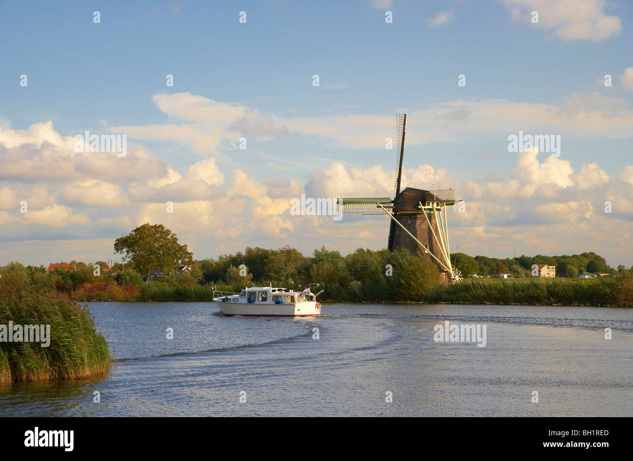 Un motoscafo sul fiume Vecht guidando attraverso un mulino a vento, Paesi Bassi, Europa Foto Stock