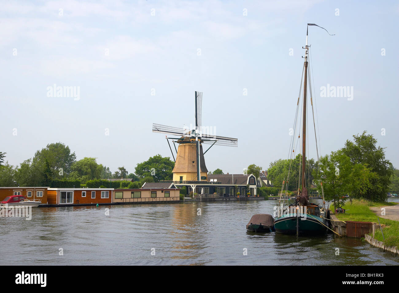 Un mulino a vento e una barca a vela presso la riva del fiume del fiume Vecht a Vreeland, Paesi Bassi, Europa Foto Stock