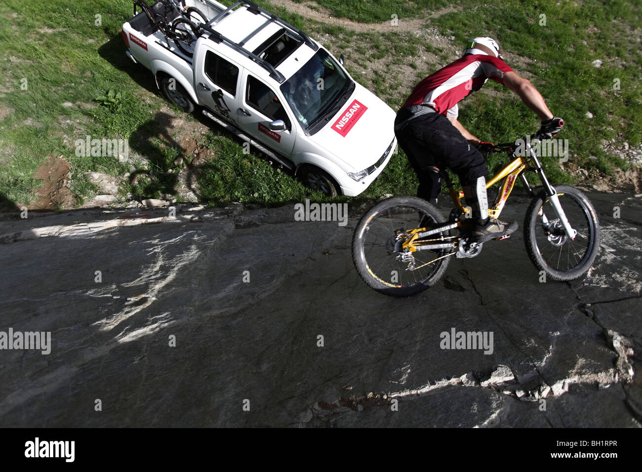 Mountainbiker a cavallo su una ripida roccia, Ischgl, Tirolo, Austria Foto Stock