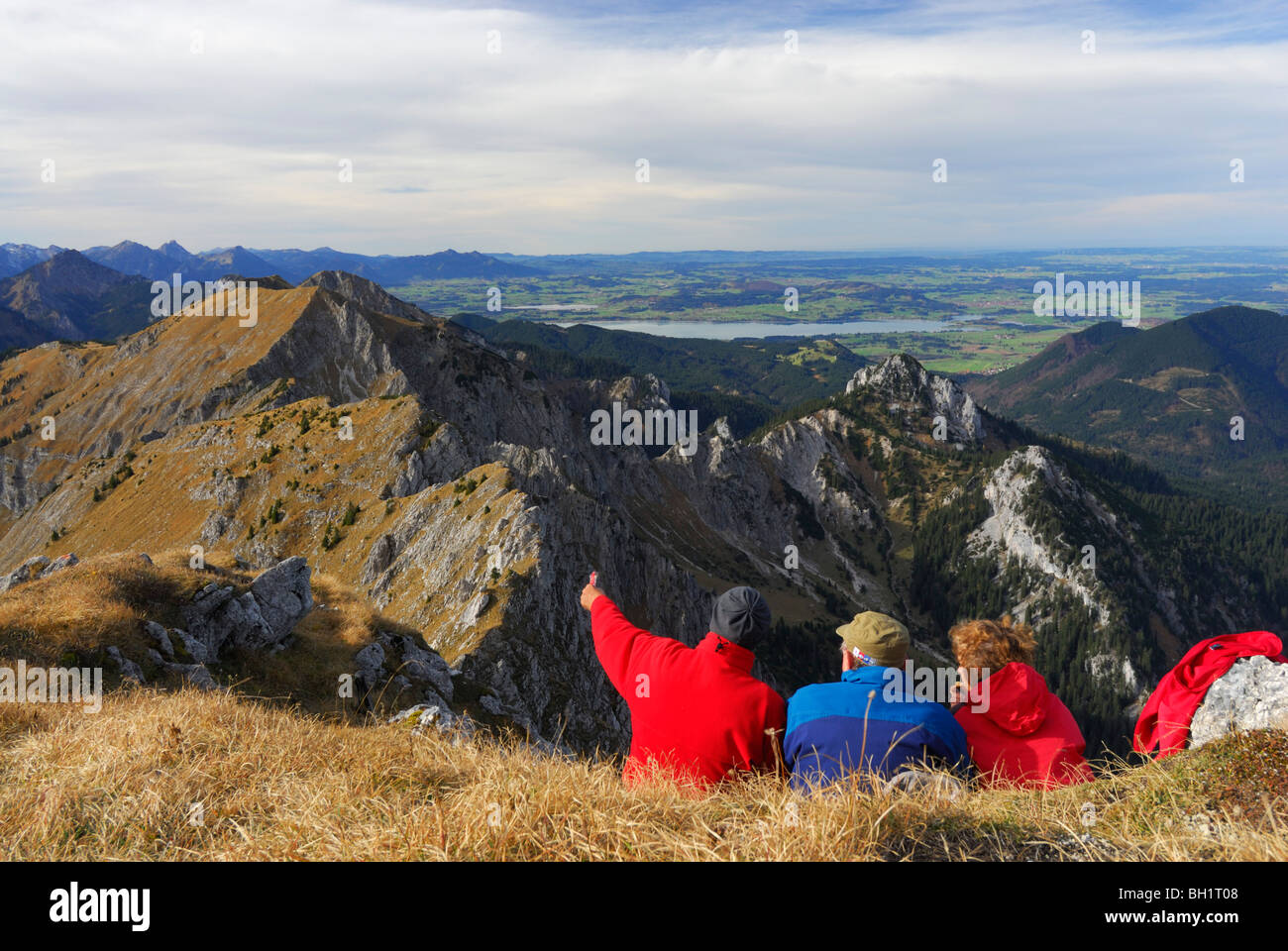 Gli escursionisti godendo di vista sulle Alpi Ammergau, lago di Forggensee in background, Klammspitze, Alpi Ammergau, Pfaffenwinkel, Baviera, germe Foto Stock