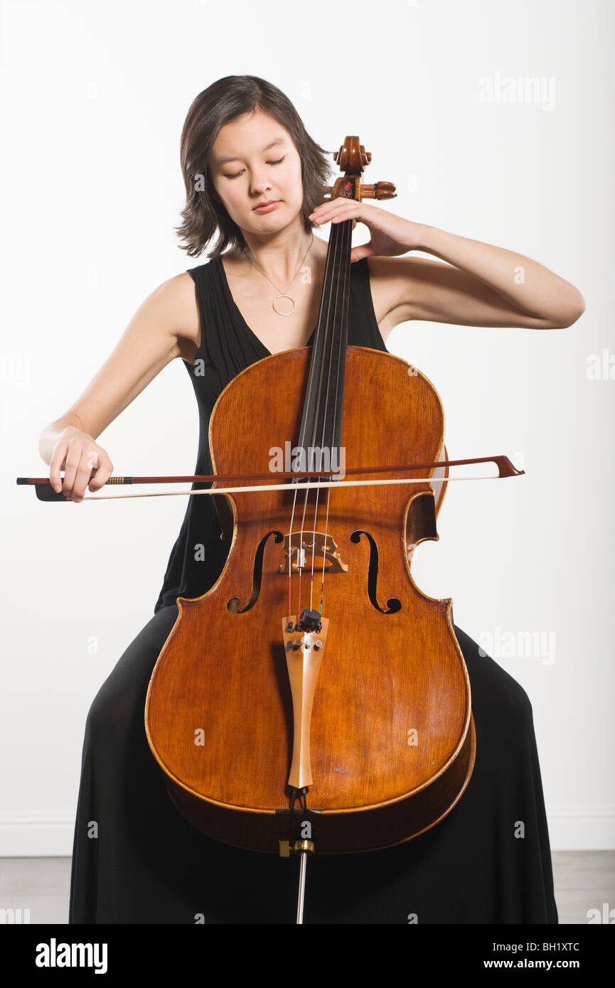 Razza mista violoncellista siede la riproduzione Foto Stock