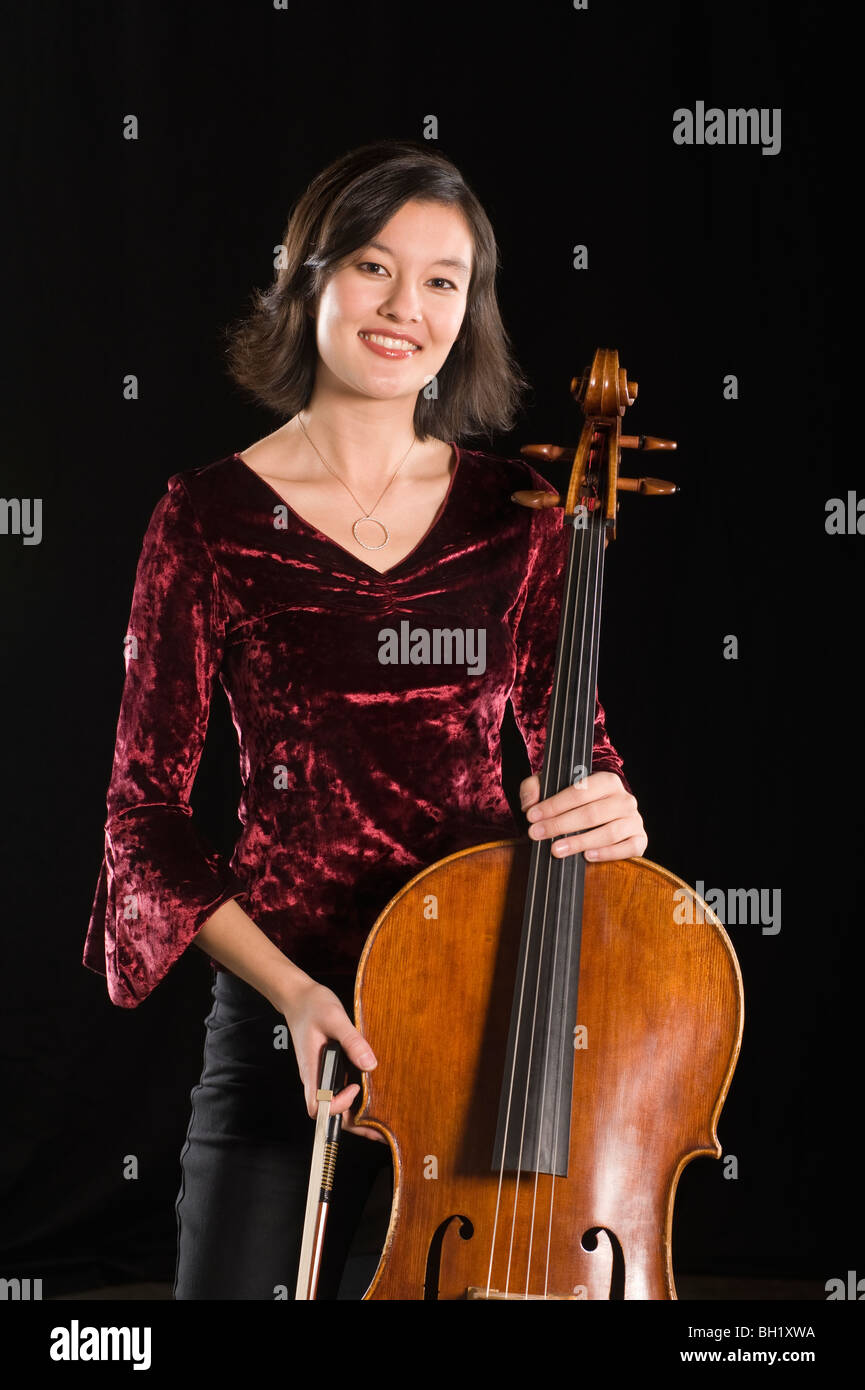 Violoncellista femmina si erge con violoncello, ritratto Foto Stock