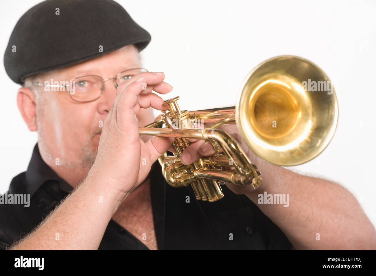 Uomo maturo nel tappo piatto a suonare la tromba Foto Stock