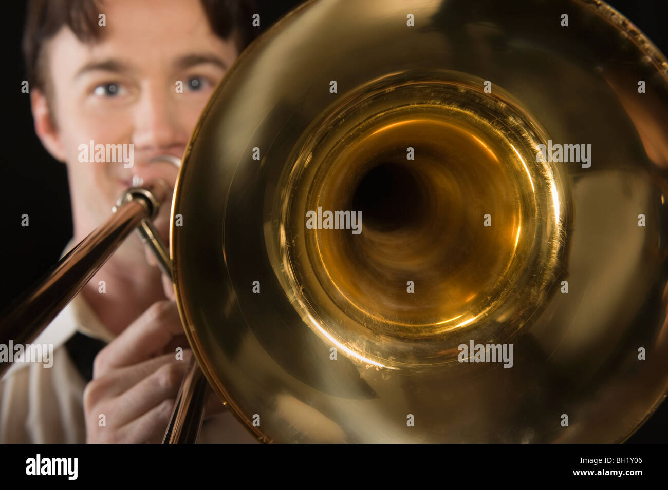 Metà di uomo adulto con open-collare shirt riproduce il trombone Foto Stock