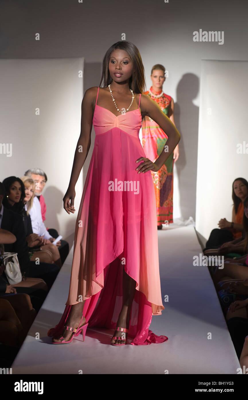 Donna in abito rosa sulla passerella per sfilate di moda Foto Stock