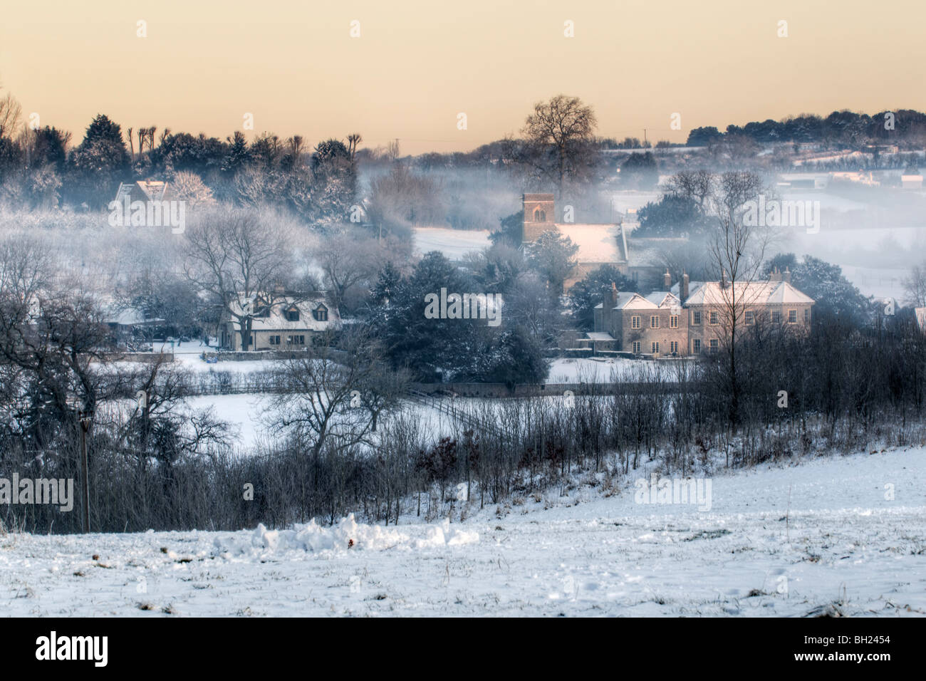 Il pittoresco neve invernale scena della St Anne's Chiesa e case di villaggio Siston vicino a Bristol, South Gloucestershire presi all'alba Foto Stock