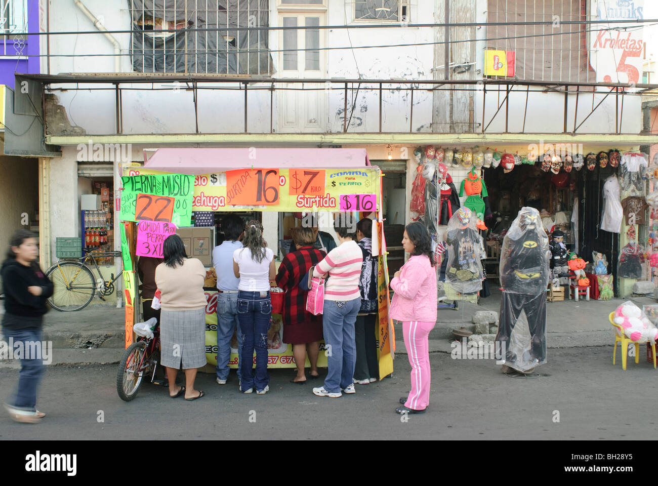 Le donne la linea fino a comprare pollo fresco da una strada di stand in Ciudad Nezahualcoyotl, Messico. Foto Stock