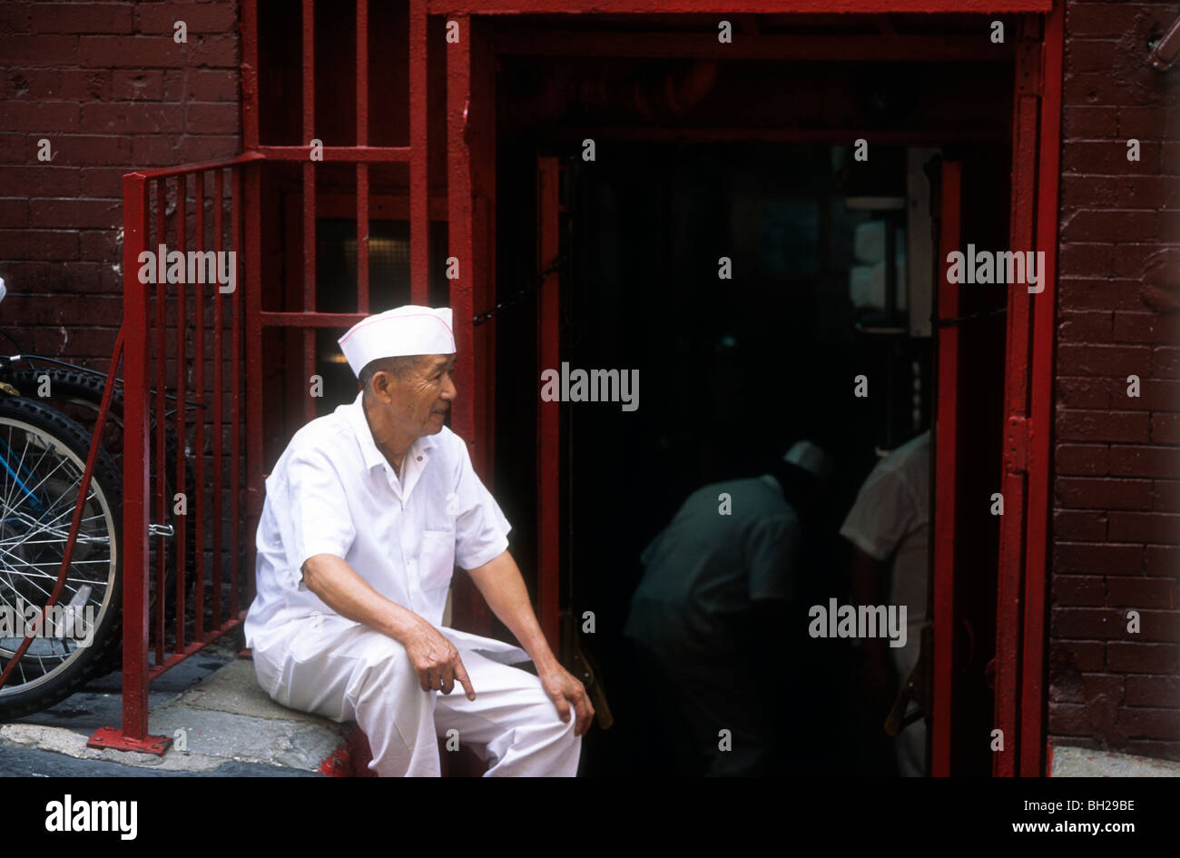 Lo Chef seduti al di fuori di un ristorante cinese in pausa Foto Stock