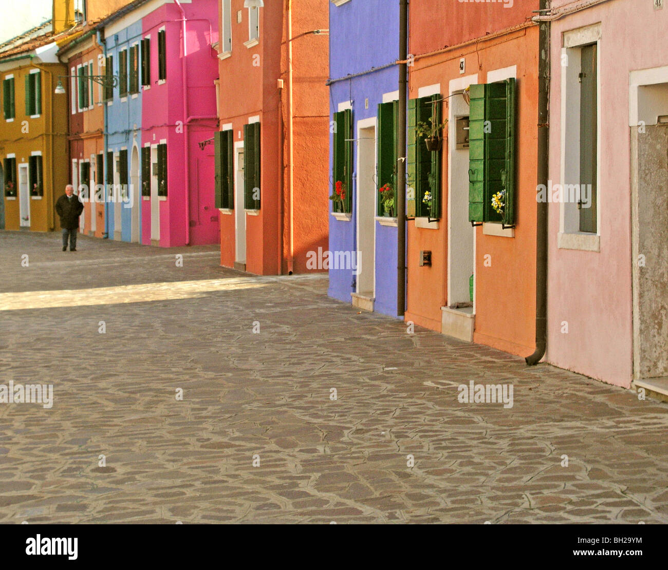 Case colorate vicino al canal sull isola di Burano Venezia Italia stone a piedi modi in cui il colore più finestre e portali uomo a camminare Foto Stock