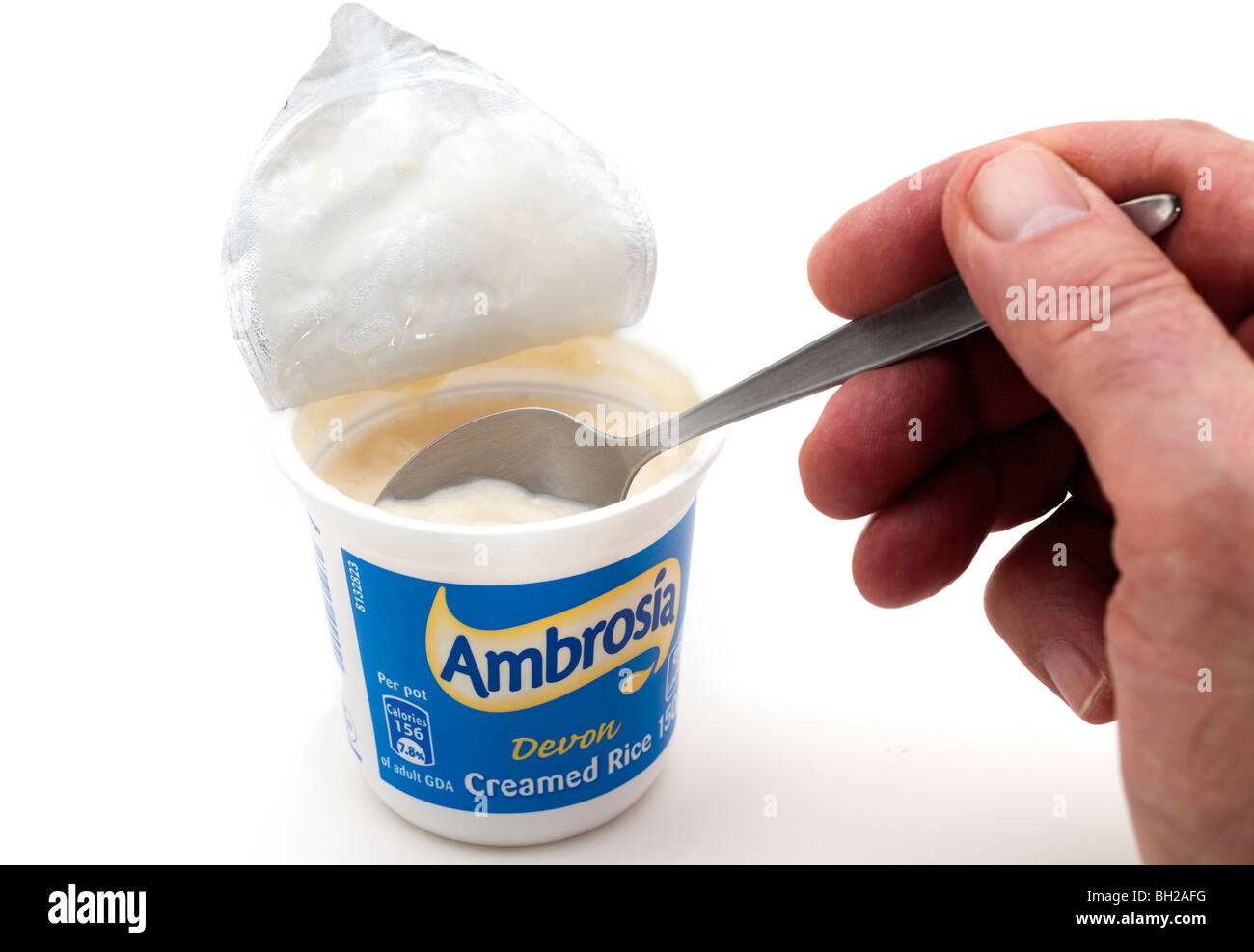 Cucchiaio all'interno di un piccolo di plastica 150gram astuccio di plastica di Ambrosia Devon crema di riso Foto Stock