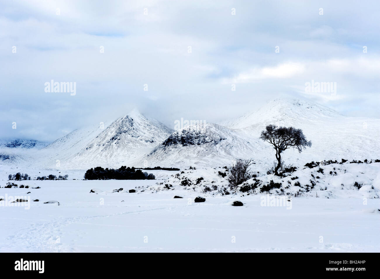 Guardando attraverso un congelati lochan nah-achlaise ai picchi della gamma Blackmount di montagne in inverno. Foto Stock
