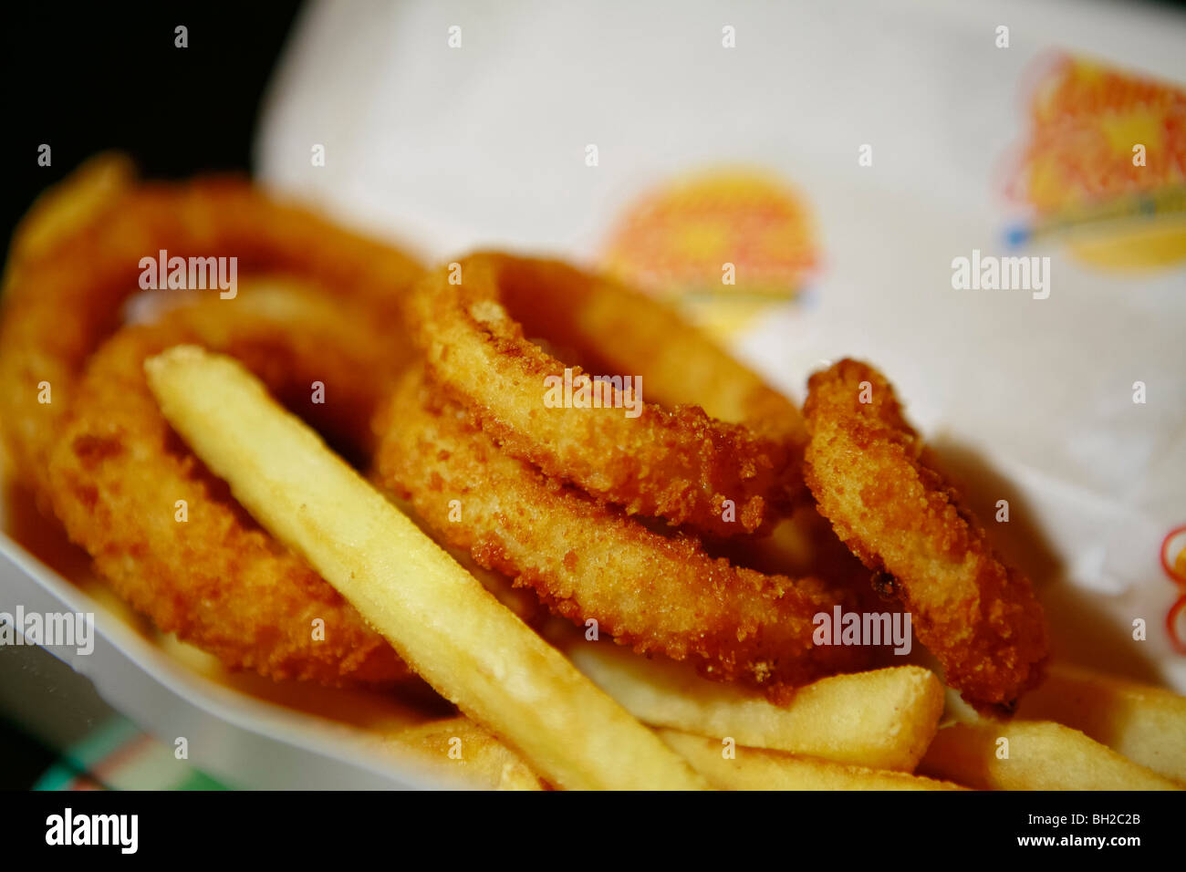 Tipico New York cheese burger, conosciuto anche come hamburger con formaggio, patate fritte, Coke e anelli di cipolla Foto Stock