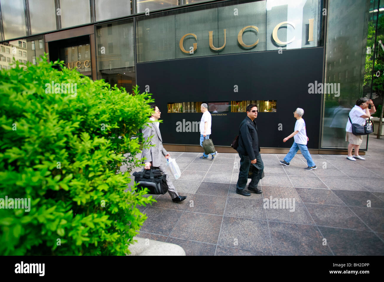 I pedoni a piedi dal negozio di Gucci sulla Quinta Avenue Foto Stock