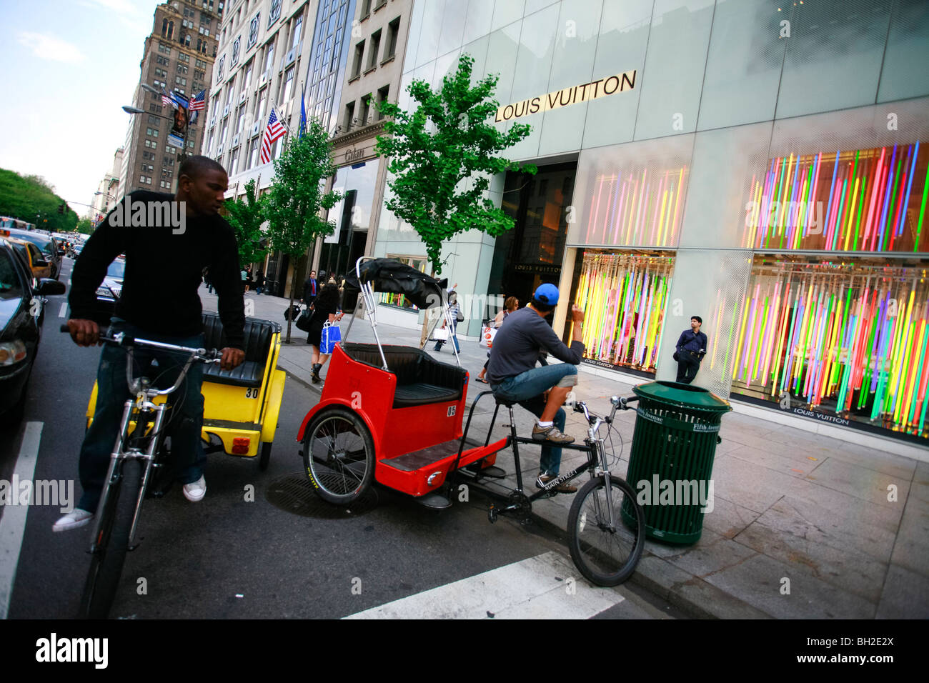 Tricicli in attesa per il turista di fronte a un negozio Louis Vuitton sulla Quinta Avenue Foto Stock