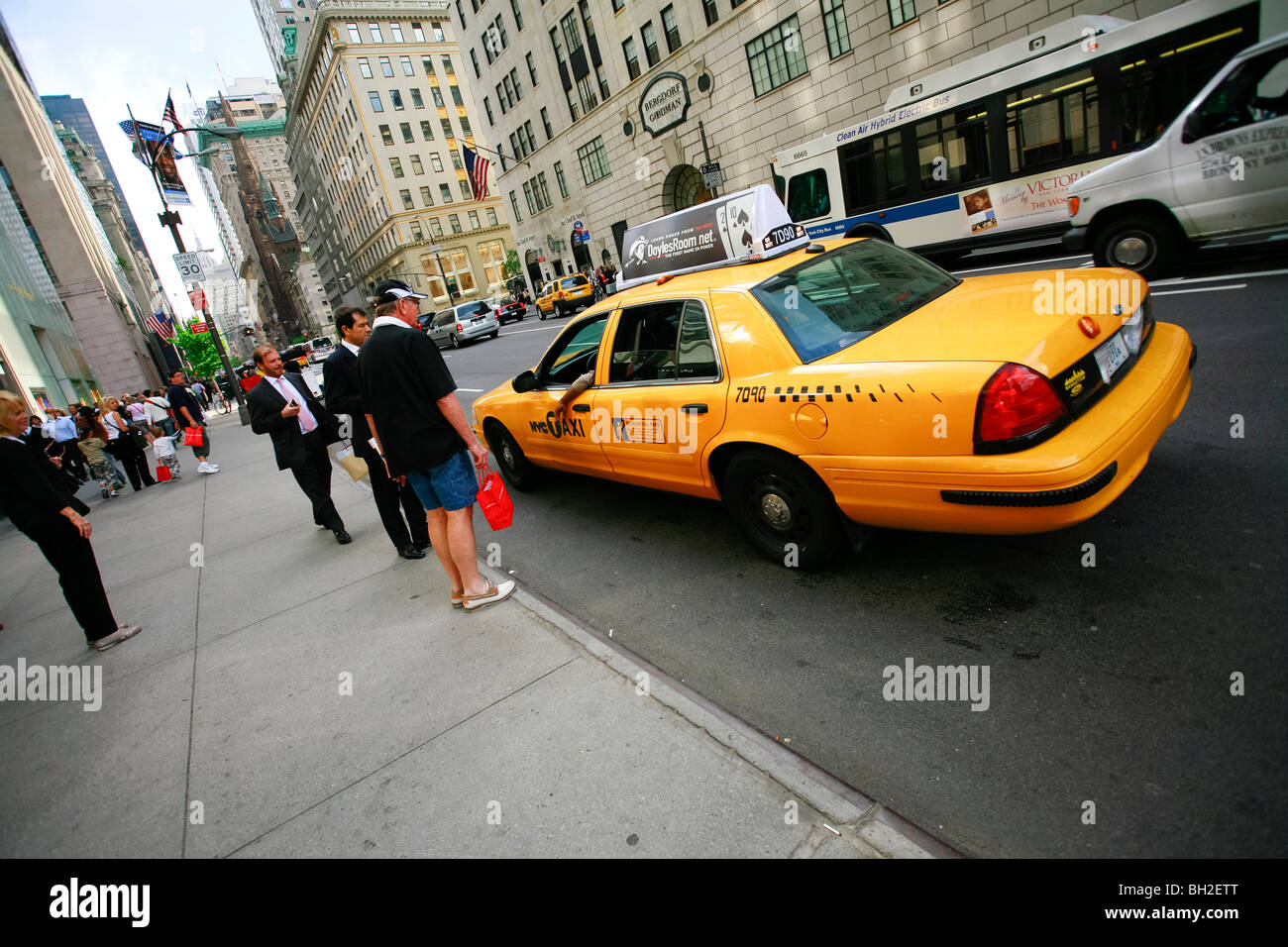 Gli uomini d' affari prendendo un taxi giallo sulla Quinta Avenue in New York Foto Stock
