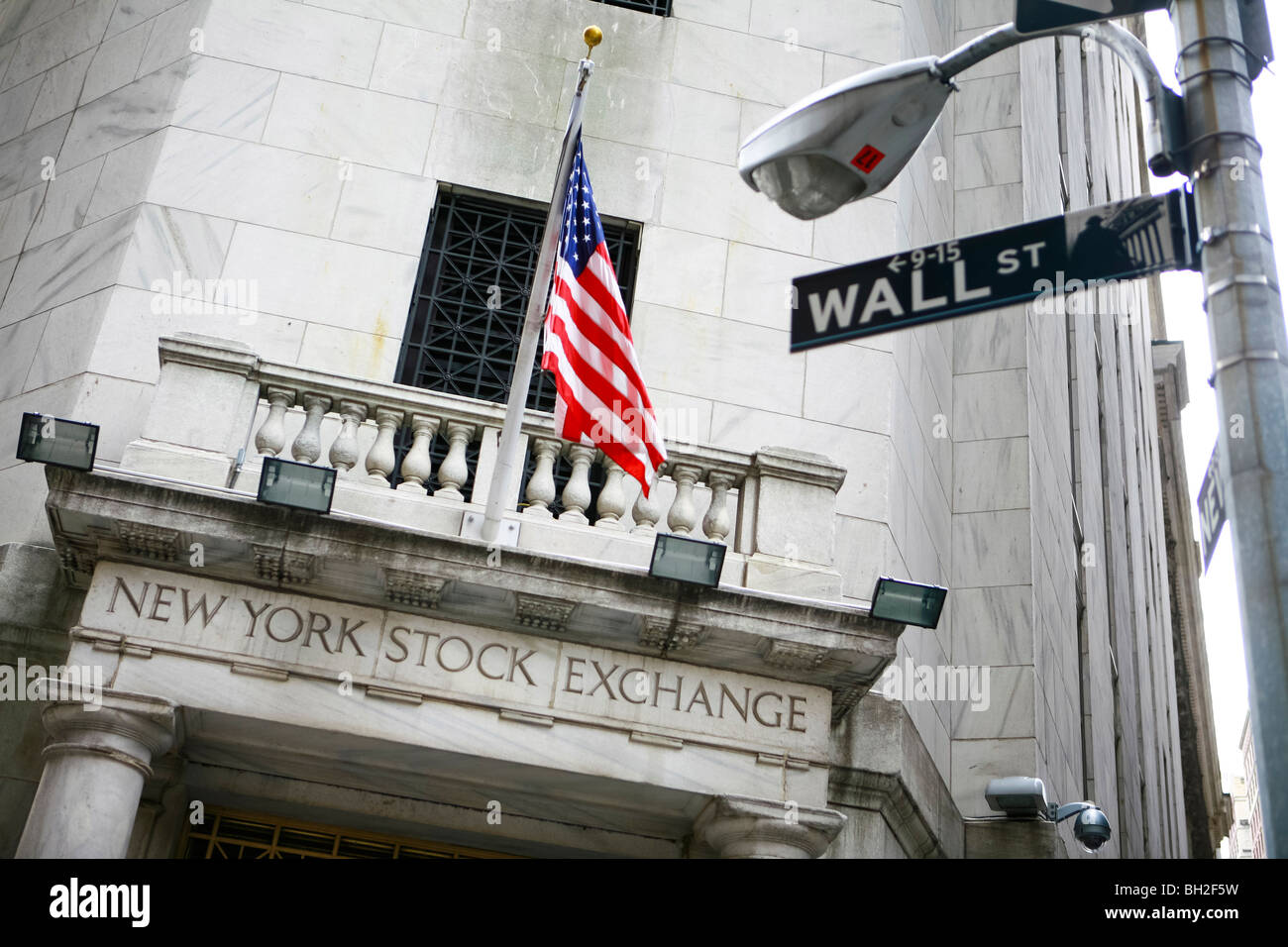Wall Street e il New York Stock Exchange di New York con un enorme bandiera americana Foto Stock