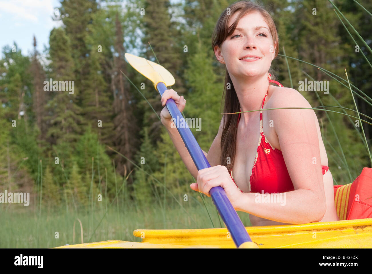 Giovane donna in giallo kayak, Lago di Katherine, Equitazione Mountain National Park, Manitoba, Canada Foto Stock