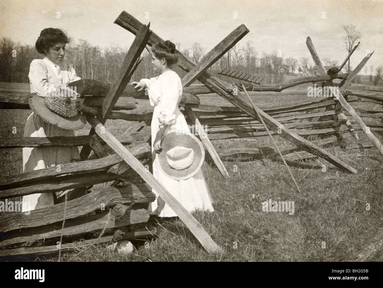 Due donne spettegolare al recinto Split-Rail Foto Stock