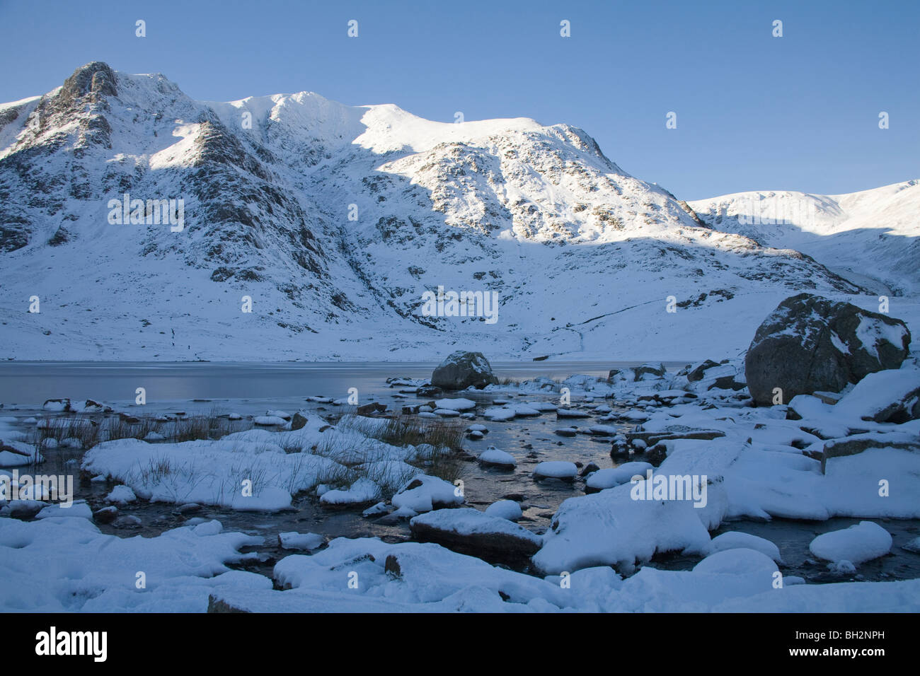 Ogwen Conwy Valley North Wales gennaio guardando attraverso la congelati Llyn Idwal su un inverni nevosi giorno Snowdonia Nationl Park Foto Stock