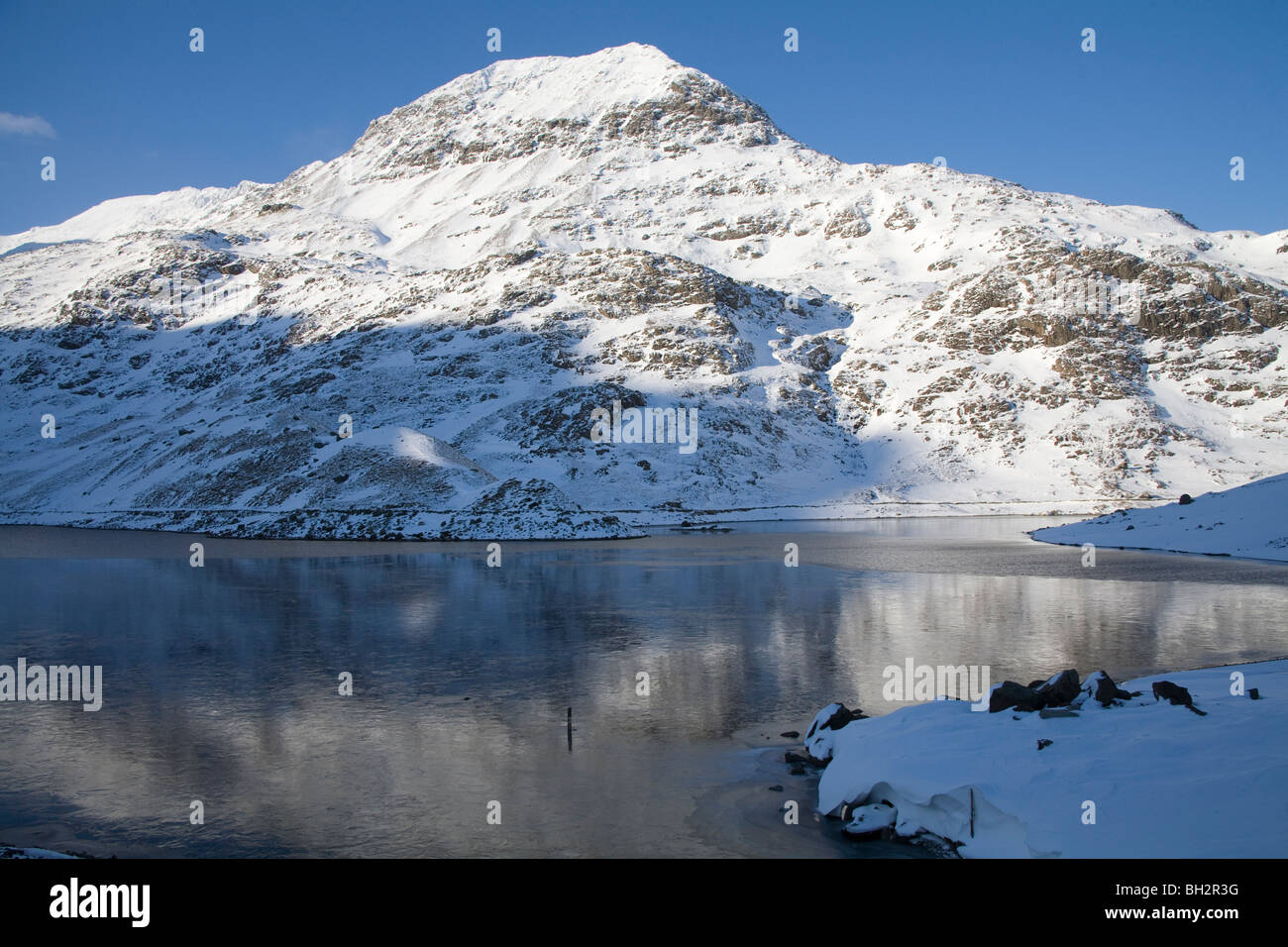 Gwynedd North Wales UK Gennaio guardando attraverso Llyn Llydaw verso la coperta di neve presepe Goch da minatori via Foto Stock