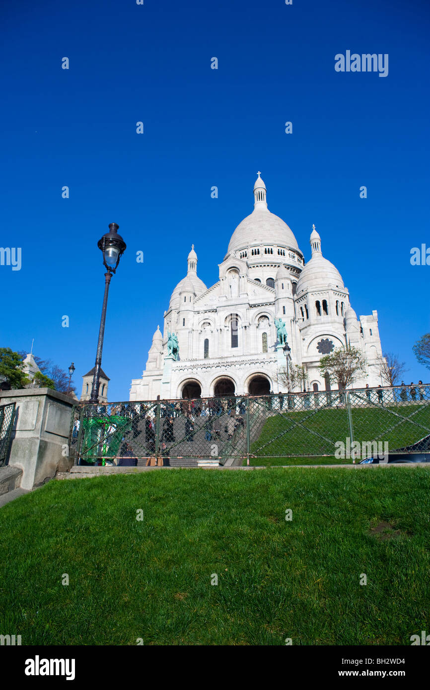 Il Sacre Coeur di Parigi con un prato verde e blu cielo Foto Stock