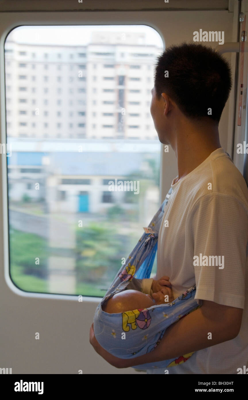 Cina .i lavoratori migranti dalla campagna tornando a casa con il bambino in treno da Guangzhou, nella provincia di Guangdong Foto Stock