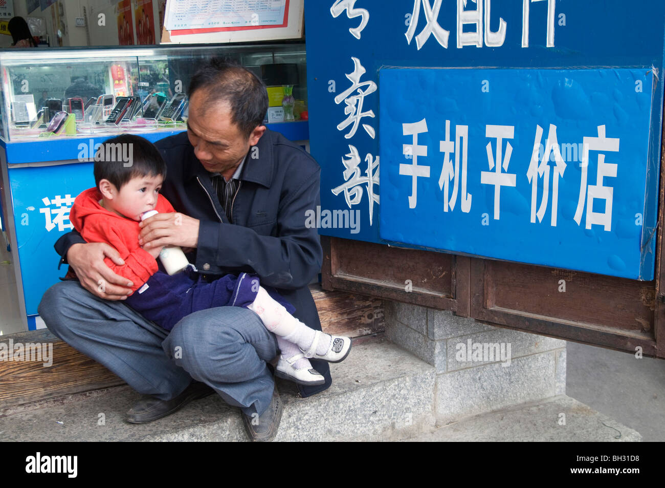 Cina .padre alimentando il suo figlio a Dali, nella provincia dello Yunnan. Foto di Julio Etchart Foto Stock