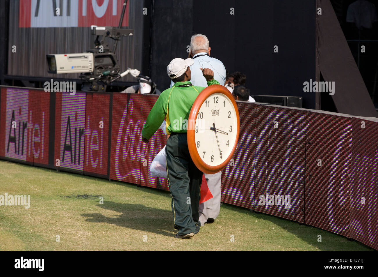 Un uomo indiano porta un grande orologio intorno al di fuori campo lato il Kotla Stadium di New Delhi, India. Foto di James Boardman Foto Stock