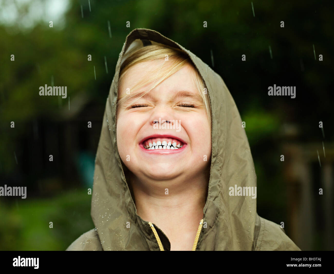 Ragazza sorridente mentre piove Foto Stock