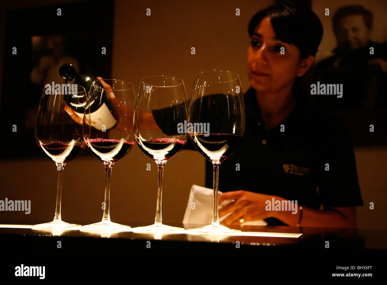 Donna versando il vino presso la sala degustazione di vitigni di Mendoza wine bar, Mendoza, Argentina. Foto Stock