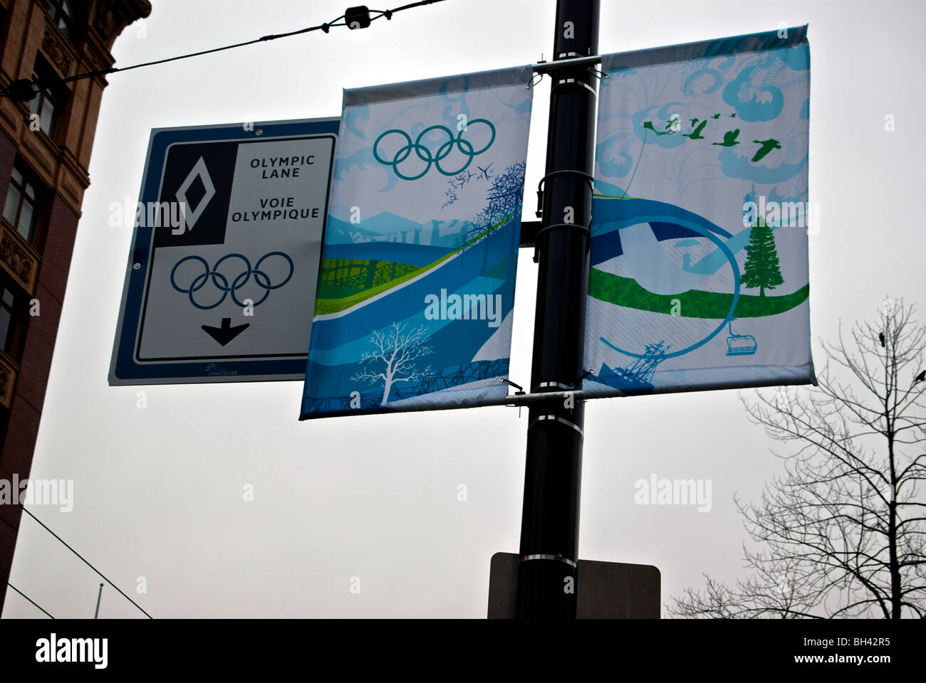 Olimpiadi Invernali 2010 panno street banner e limitato traffico olimpico lane segno contro Poco nuvoloso Nuvoloso sky Foto Stock