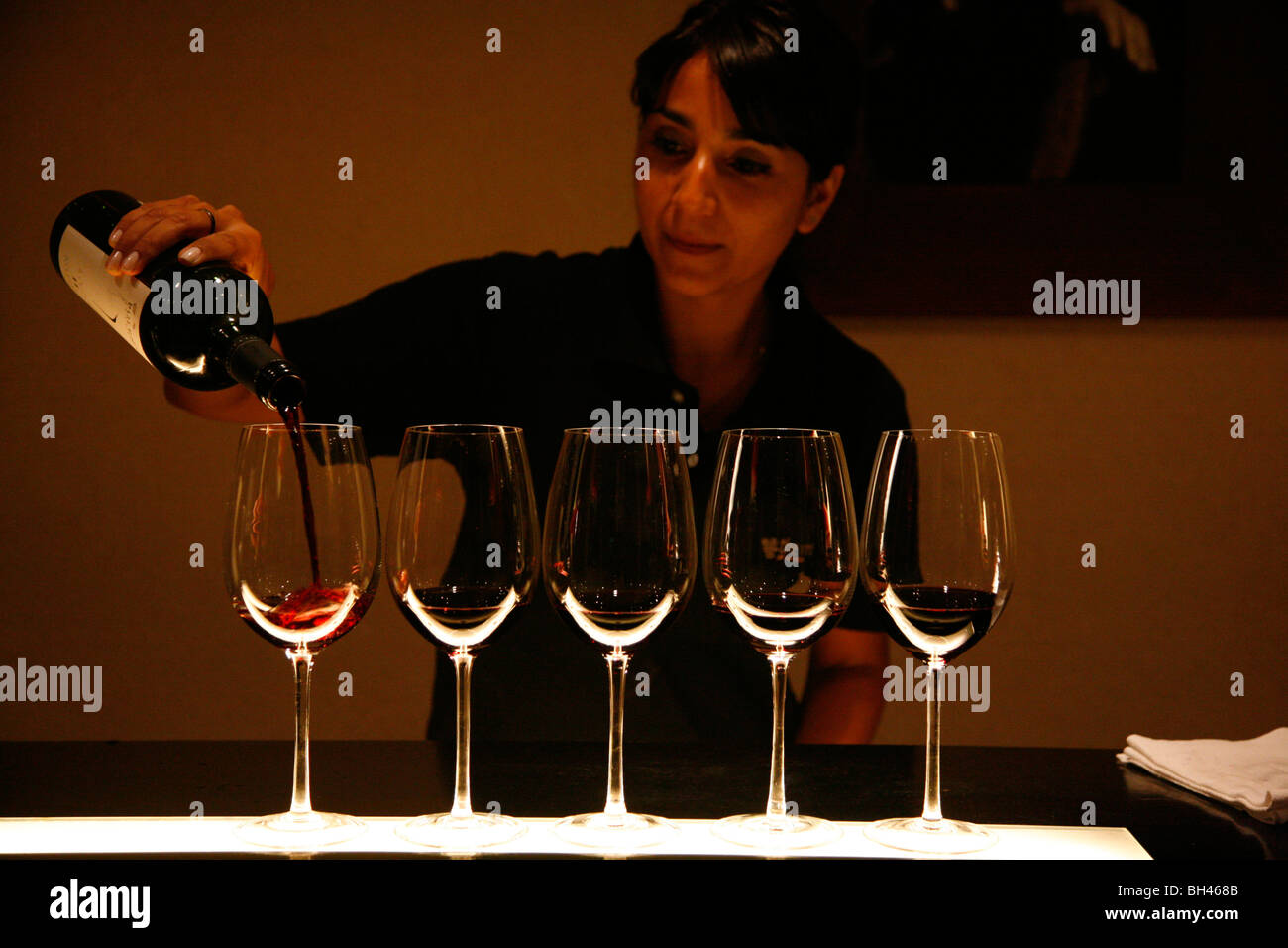 Donna versando il vino presso la sala degustazione di vitigni di Mendoza wine bar, Mendoza, Argentina. Foto Stock