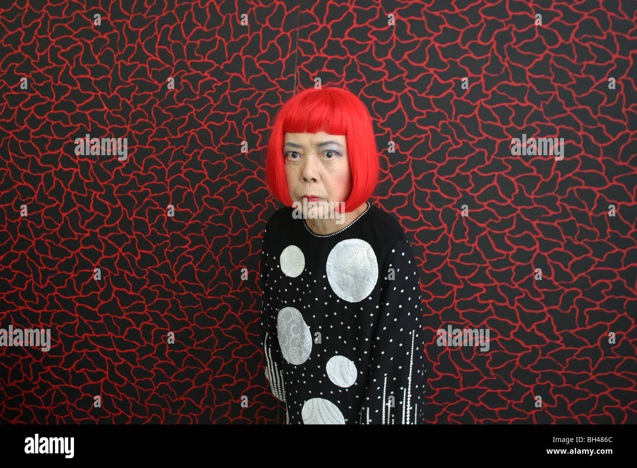 Artista giapponese Yayoi Kusama sorge nella parte anteriore di uno dei suoi dipinti nel suo studio, Tokyo, Giappone Foto Stock