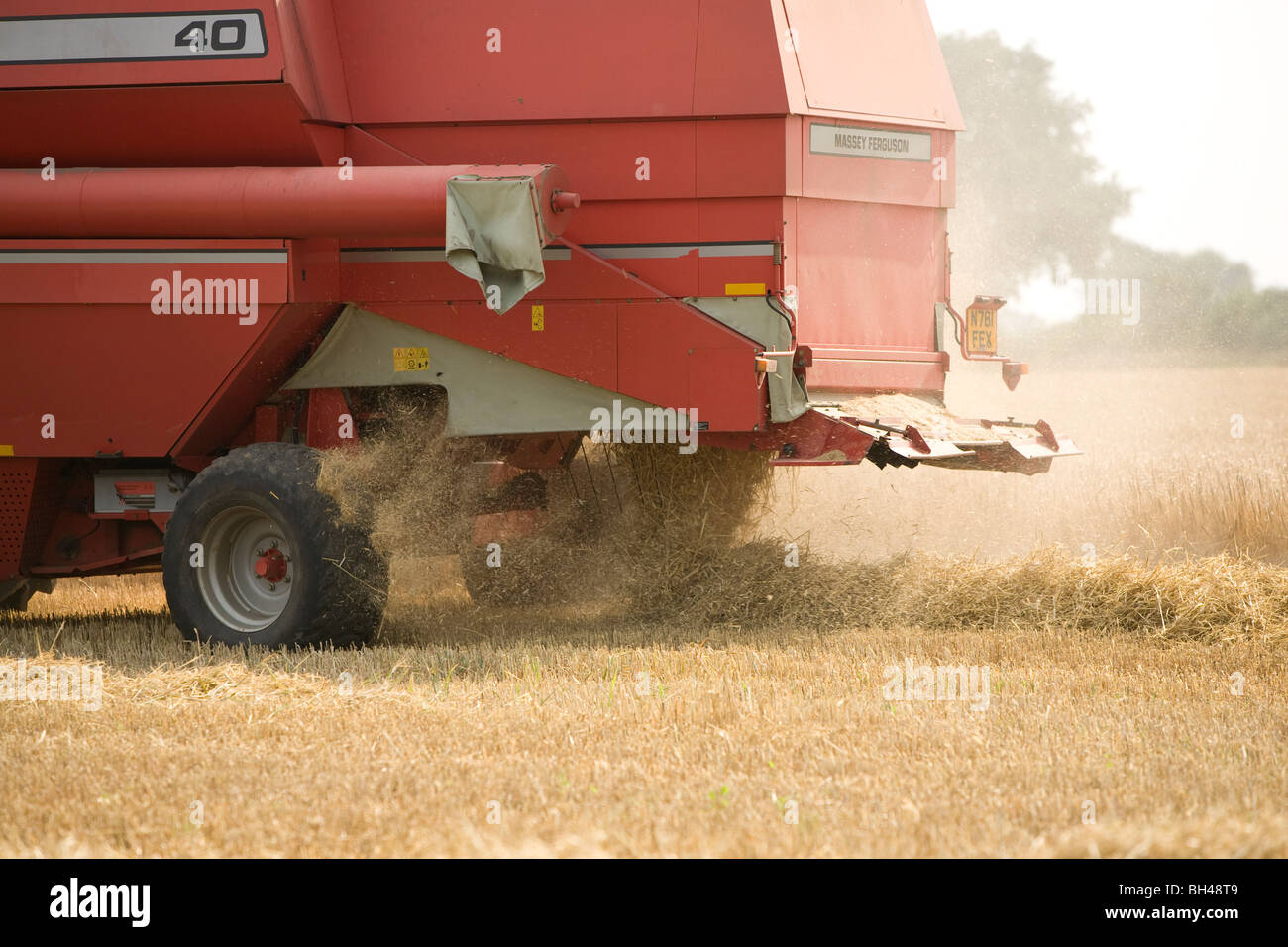 Close up della mietitrebbia facendo cadere la paglia su Norfolk farm in luglio. Foto Stock