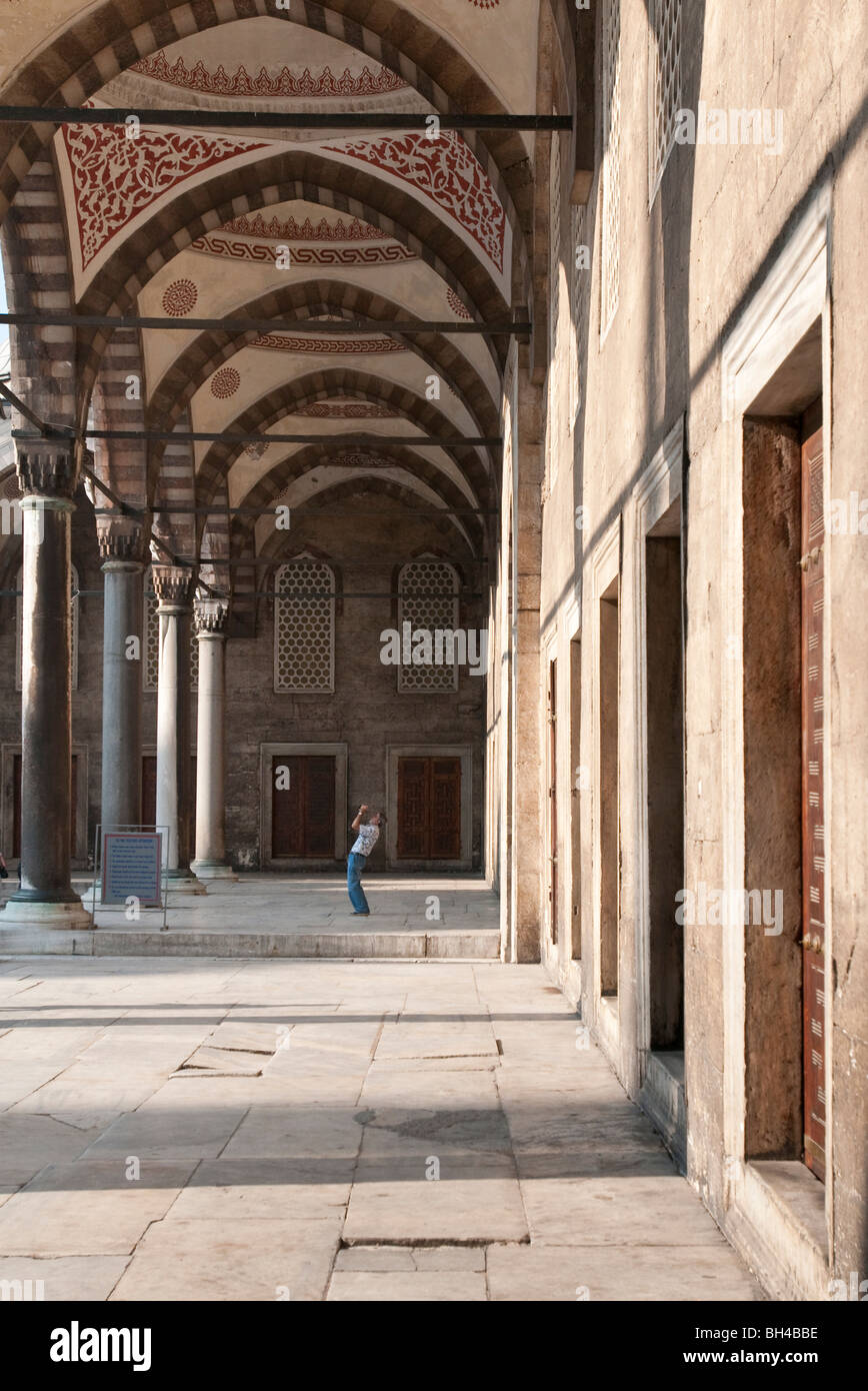 Un turista scatta una fotografia nel cortile interno della Moschea Blu, Istanbul Foto Stock
