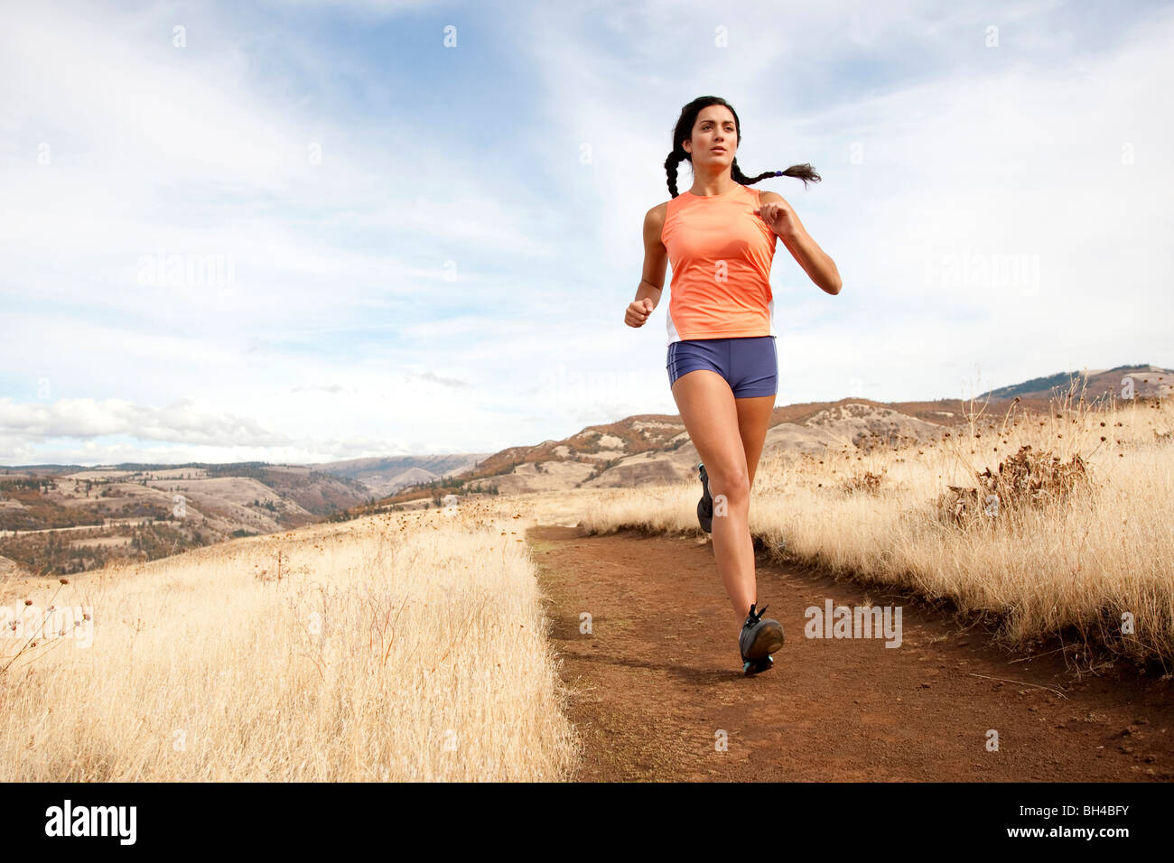 Una femmina di atletica fa avanzare su un sentiero sterrato in una giornata autunnale. Foto Stock
