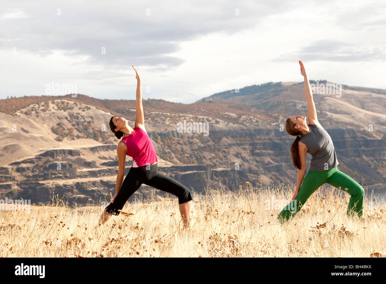 Due femmine a praticare yoga all'aperto con la Columbia River Gorge in distanza. Foto Stock