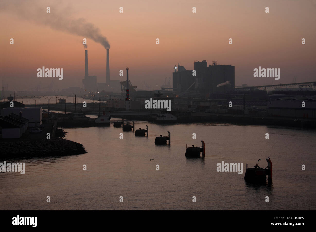 Vista di Le Havre port appena prima del sorgere del sole con comignoli fumanti in distanza. Foto Stock
