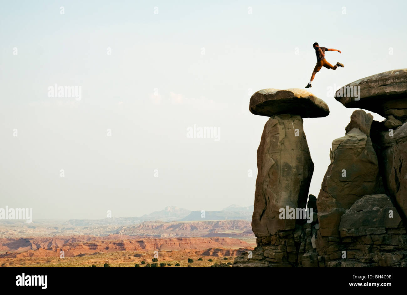 Un giovane uomo passa attraverso una serie di rocce in Moab Utah. Foto Stock