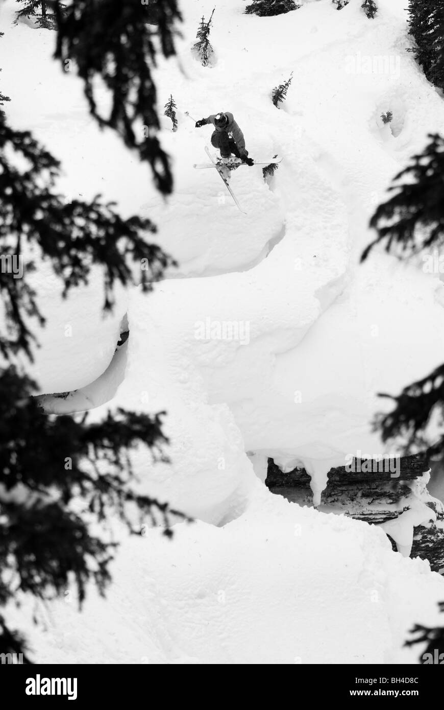 Uno sciatore scende una grande serie di rocce nelle Montagne Rocciose Canadesi backcountry. Foto Stock