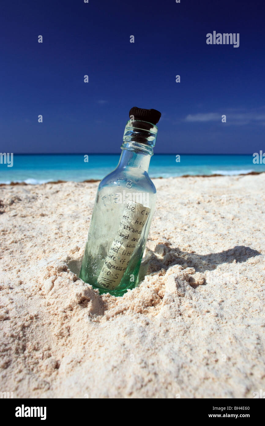 Un messaggio in una bottiglia di sabbia su una deserta spiaggia tropicale Foto Stock