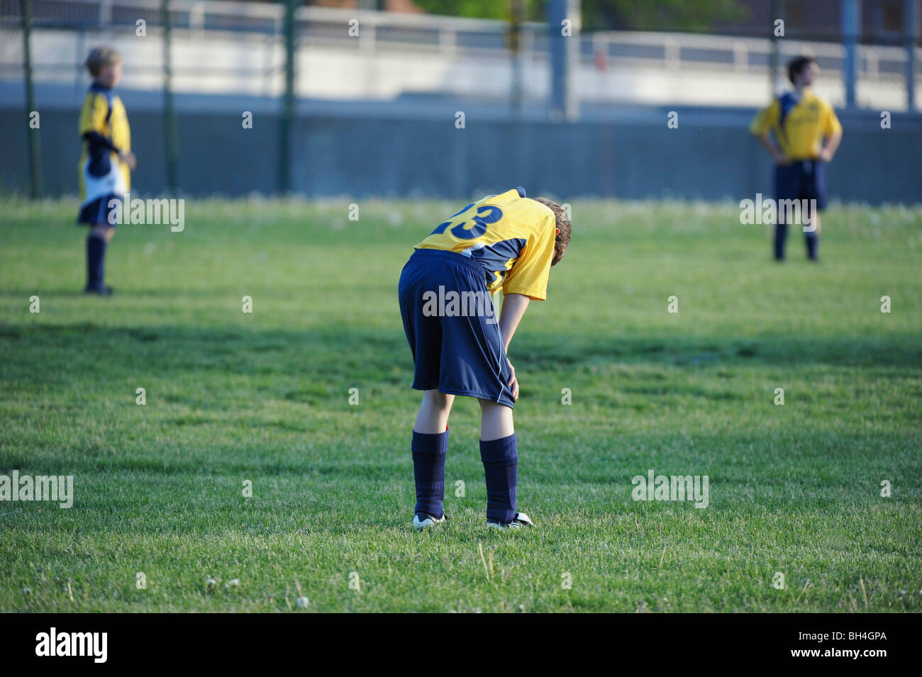 Ragazzo con la testa in giù nella partita di calcio Foto Stock