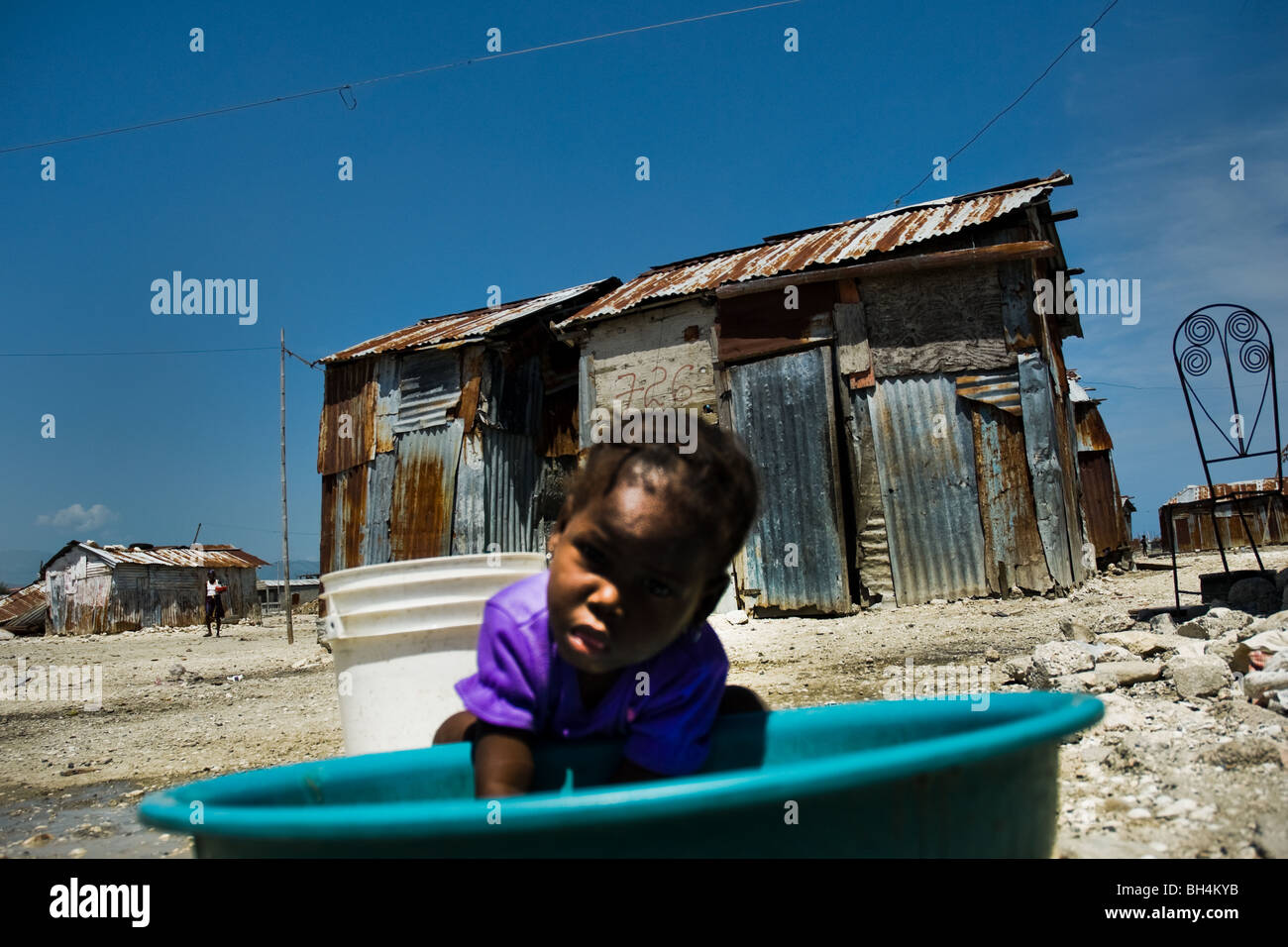 Un capretto haitiani a giocare con acqua di scarto nella baraccopoli di cité soleil. Foto Stock