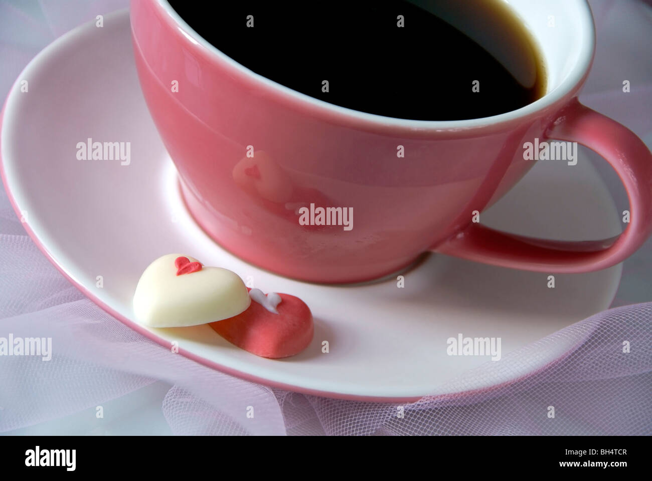 Rosa tazza da caffè con cioccolato cuori Foto Stock
