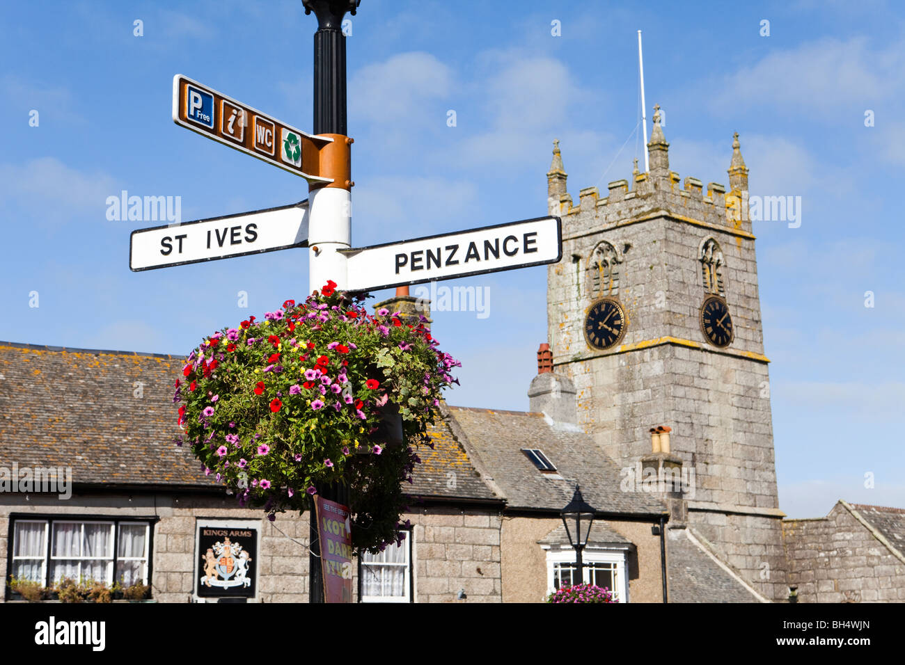 Appeso un cesto di fiori sul cartello stradale nella piazza principale della città di San Giusto, Cornwall Foto Stock