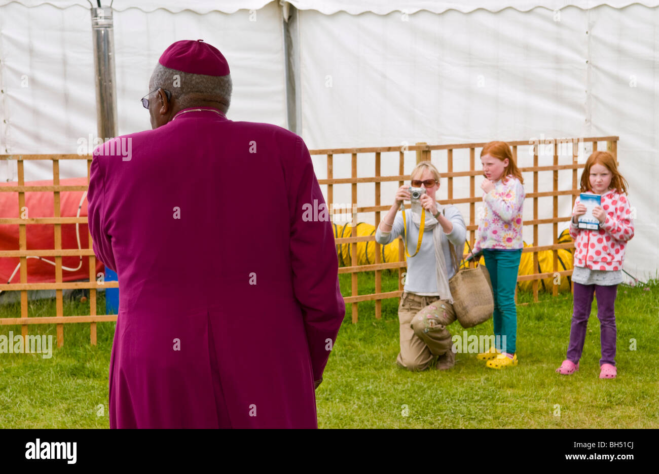 Desmond Tutu facendo una chiamata sul suo telefono cellulare guardato e fotografata da gruppo di famiglia a Hay Festival 2009. Foto Stock