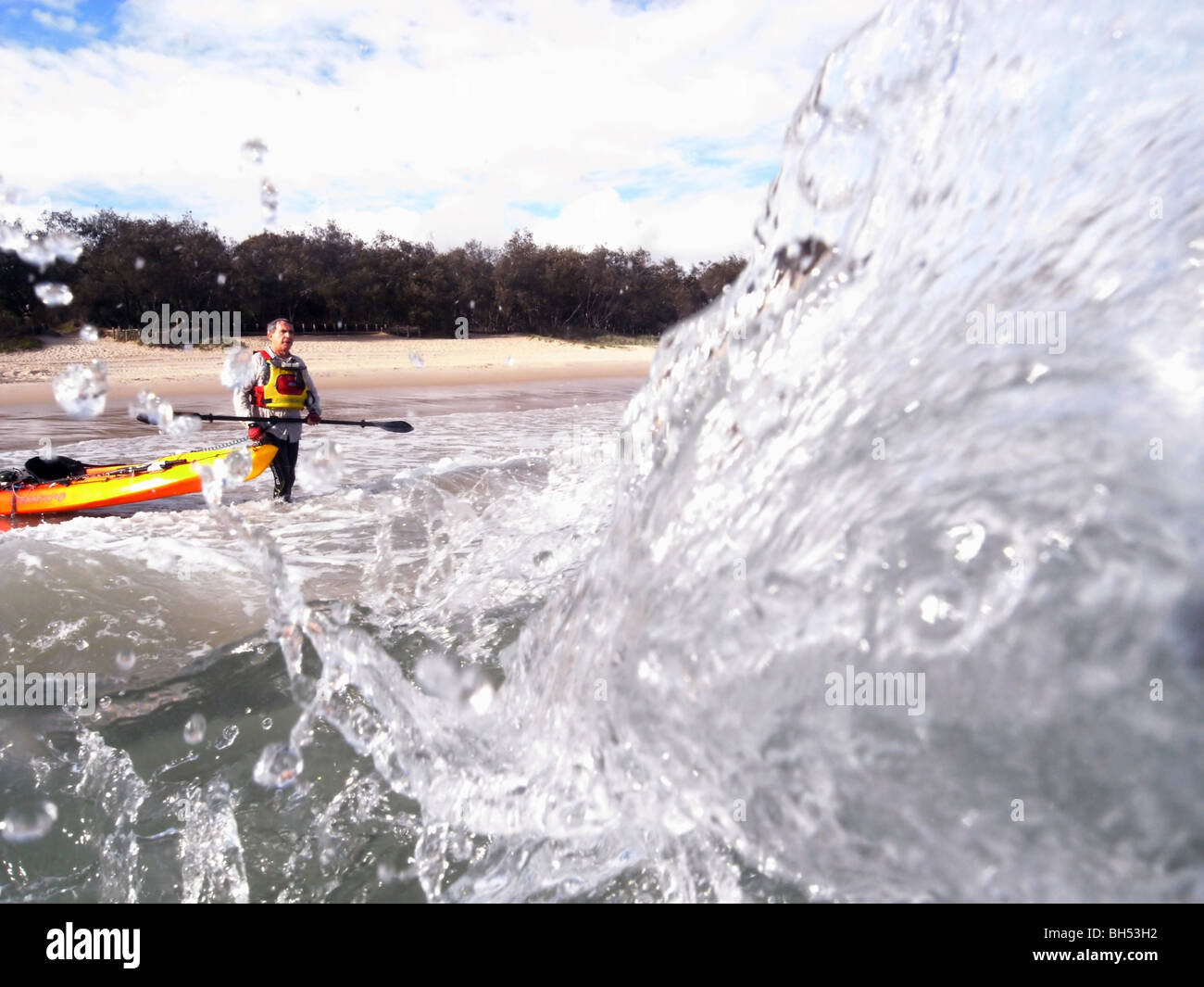 Sea kayaker di entrare pesante da surf beach, Noosa Sunshine Coast, Queensland, Australia. Signor Foto Stock