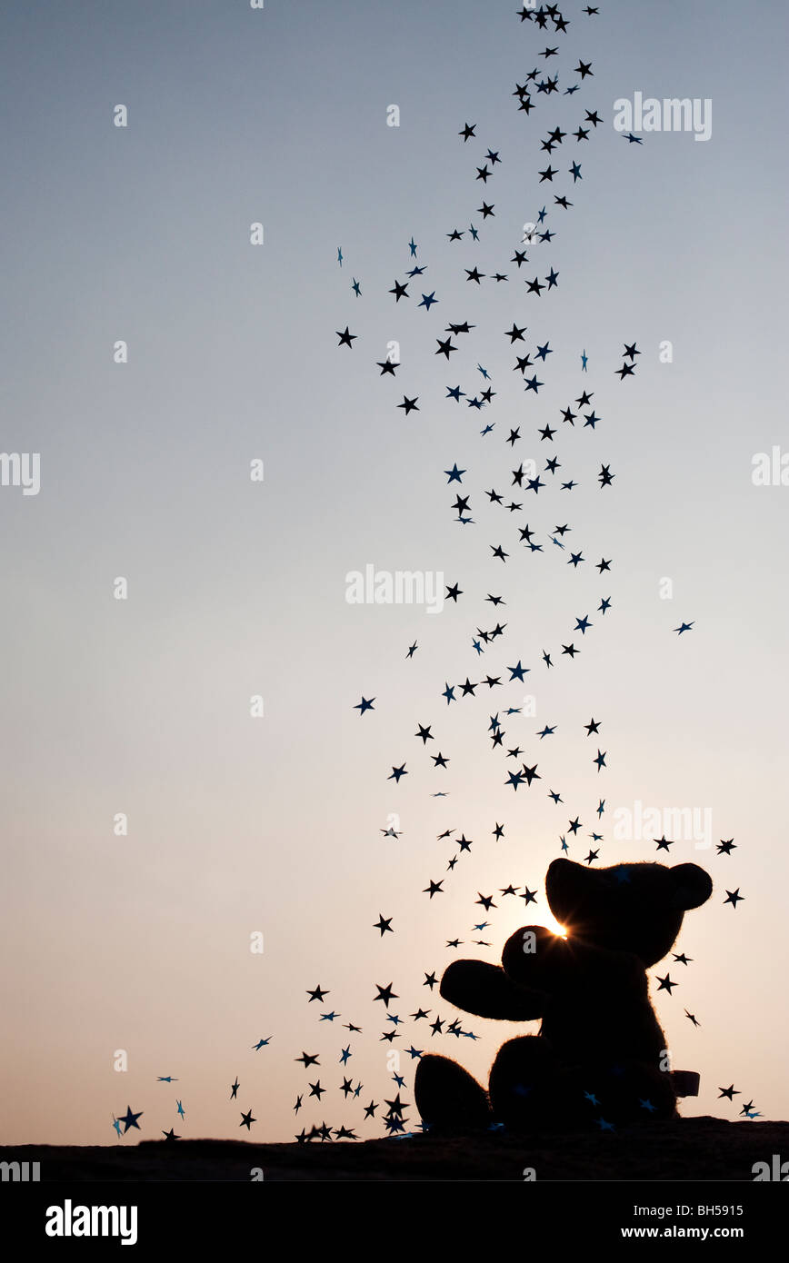 Orsacchiotto di peluche la cattura di stelle cadenti silhouette Foto Stock