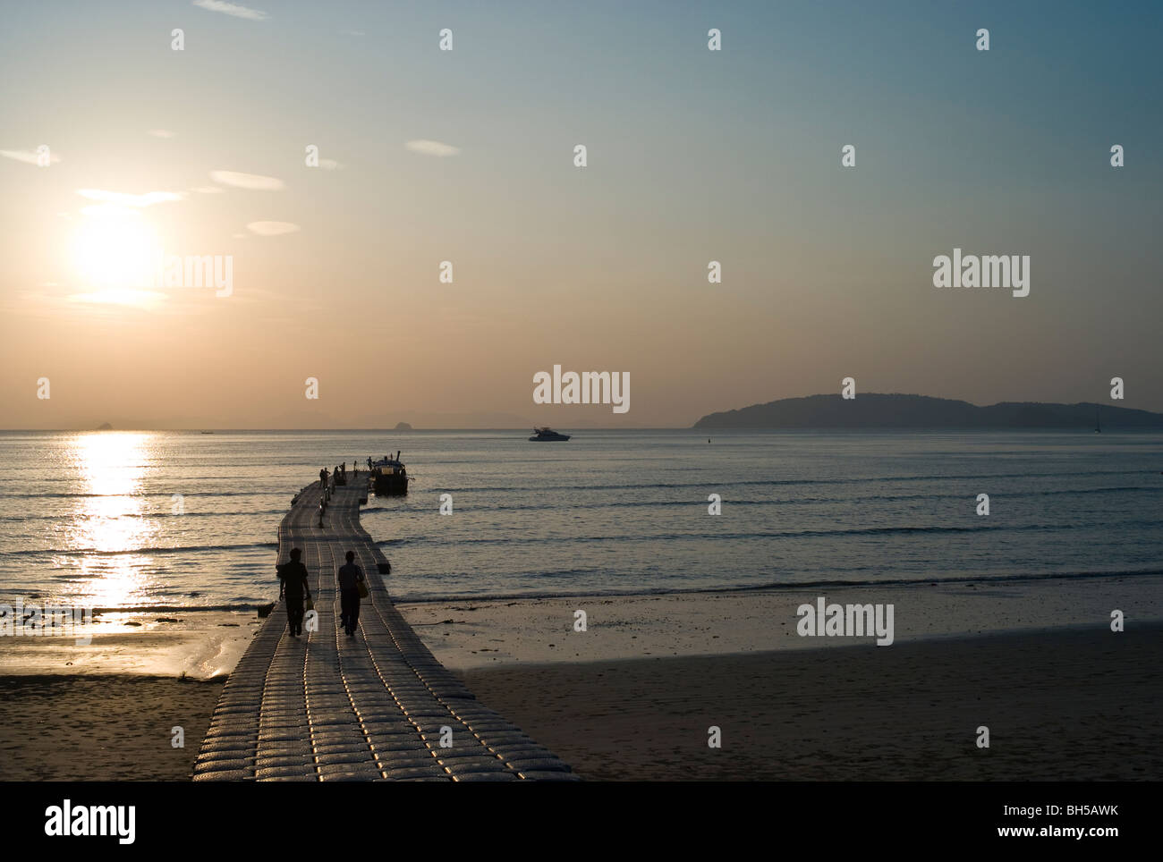 La gente che camminava su un pontile galleggiante al tramonto Krabi Thailandia Foto Stock